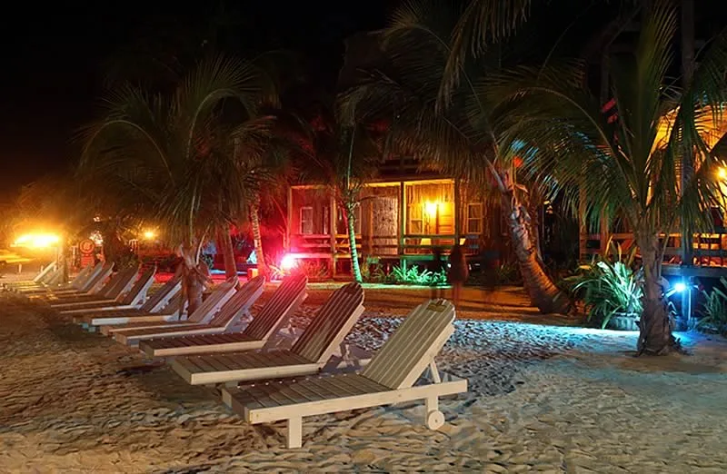 Neon lights outside beachfront cabanas at night