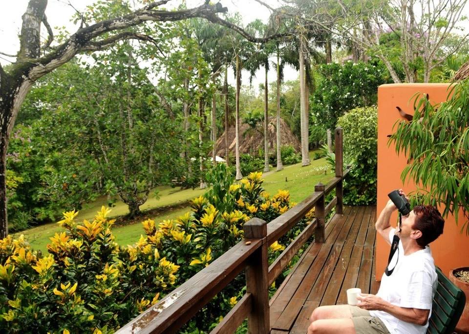 Man on a deck with binoculars at bird watching