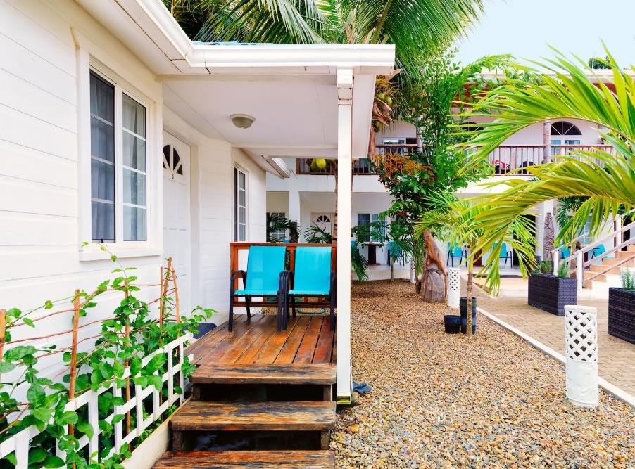 Wood porch, railing and door of a white guest house