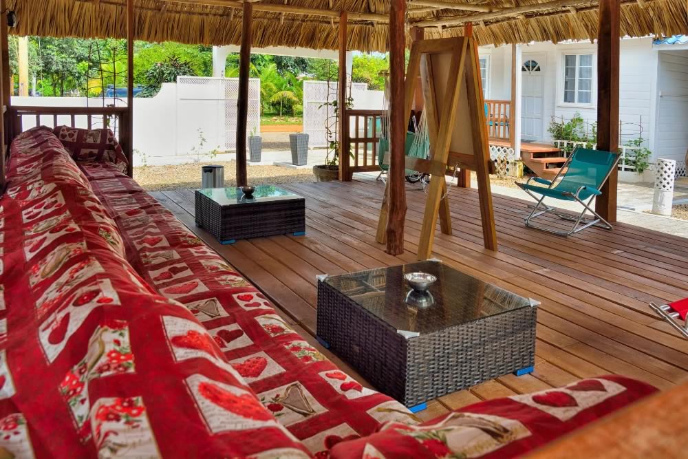 A thatched roof lounge with coffee tables and lounge sofas