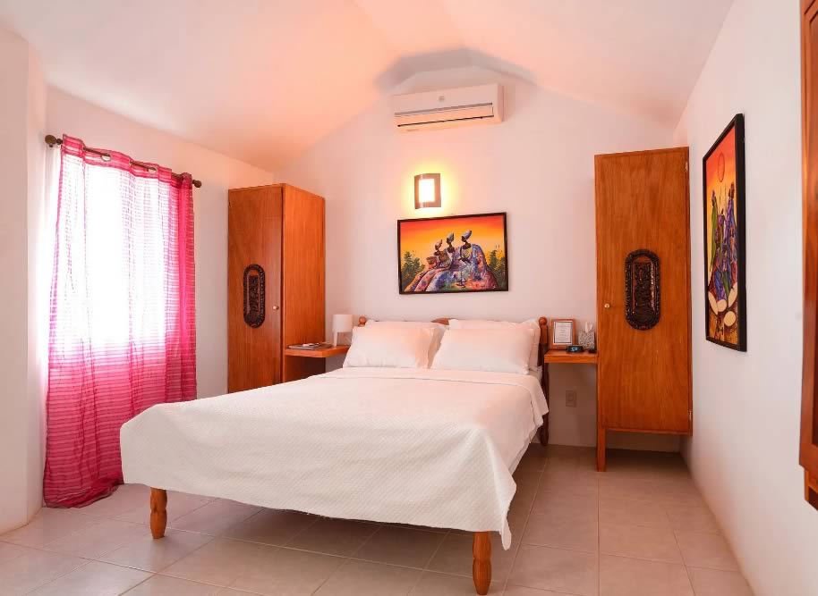 Interior of a guest house room with a king bed and closets