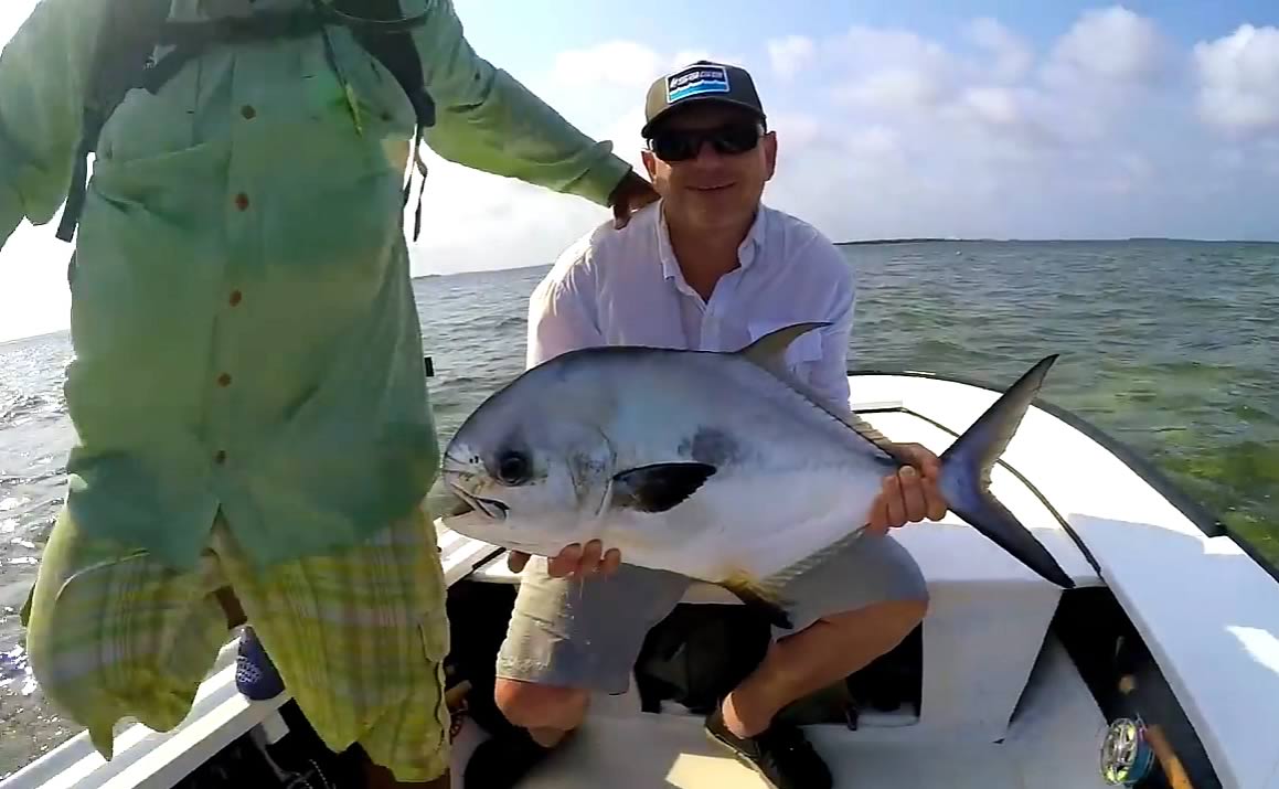 Fly fisherman poising with a permit catch