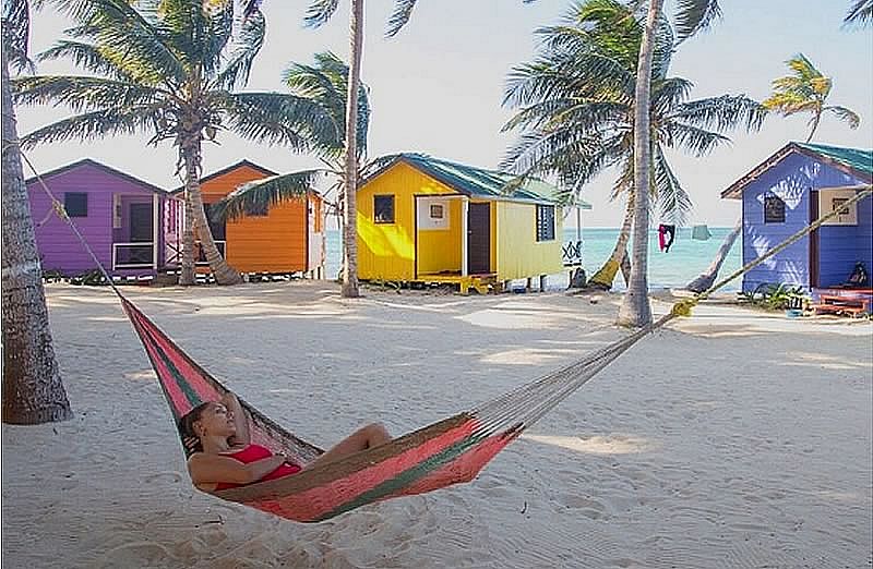 A hammock hanging over the deck of a overwater cabin