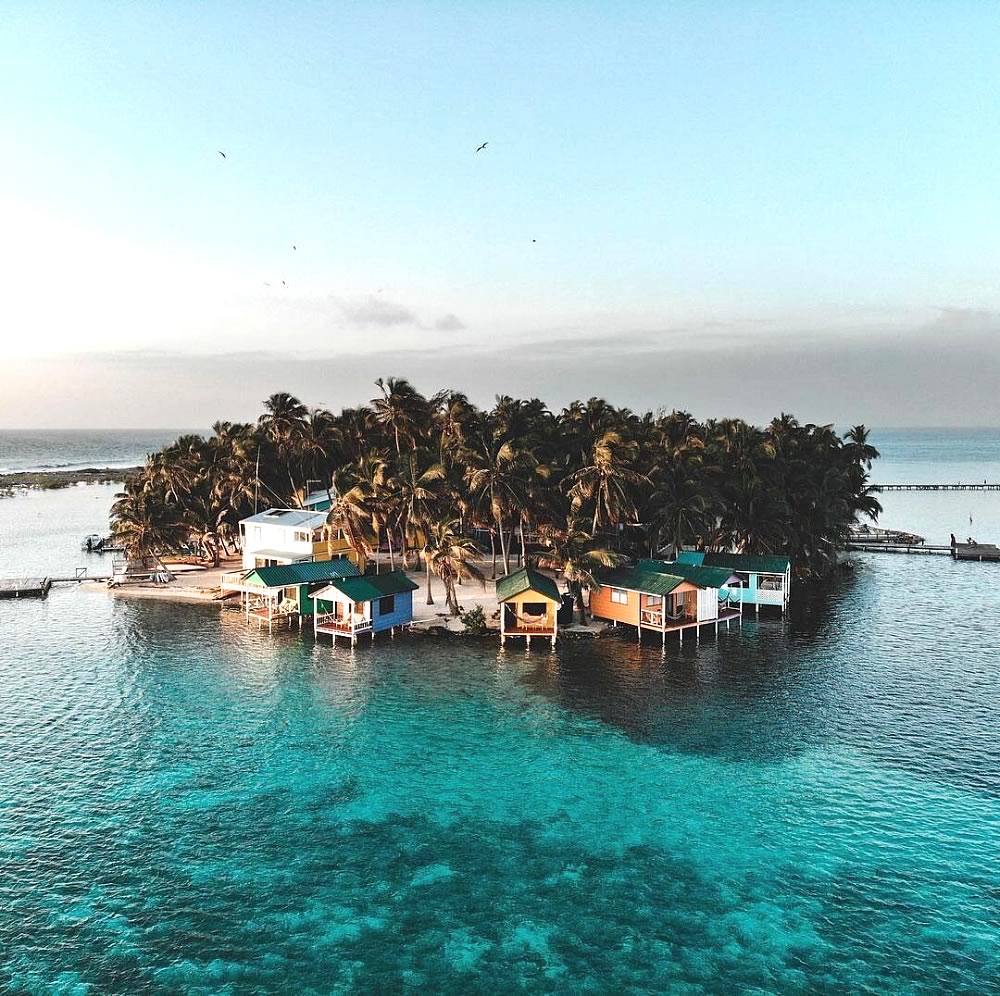 Aerial view of Tobacco Caye with overwater cabins