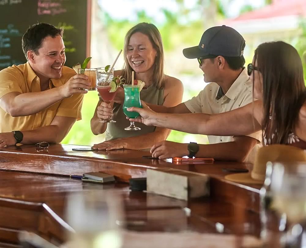 Two men and two women toasting at Turneffe Resort Bar