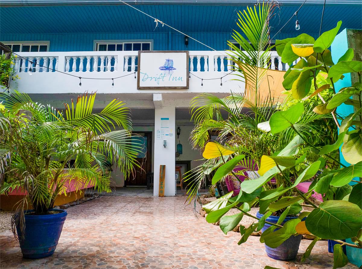 Drift Inn Hotel entrance with floor plants and sign