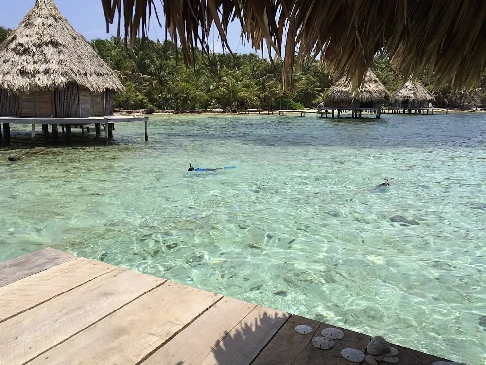 Snorkeler snorkeling between the overwater cabins at Glover's Atoll Resort